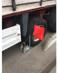 Unterlegkeil mit grün-roter Fahne am Lkw-Rad.